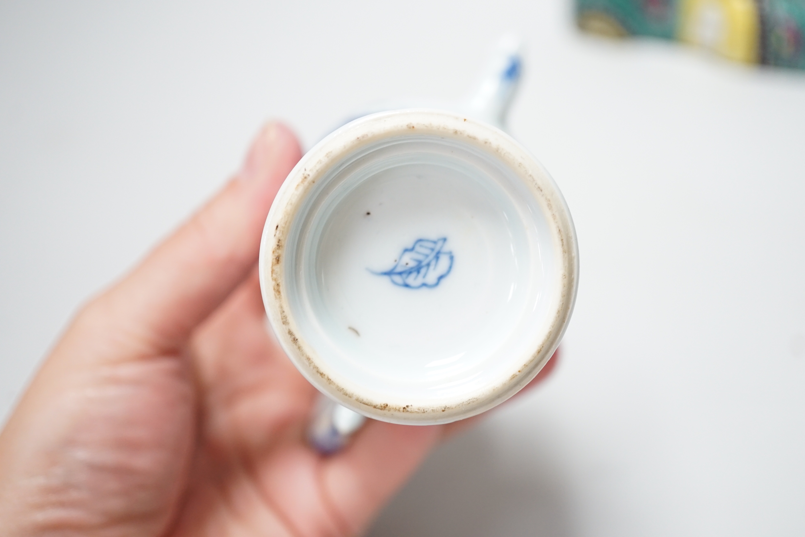 A 19th century Chinese famille enamelled porcelain figure of Budai, 17cm high and a Chinese Kangxi period blue and white small wine ewer and plated cover